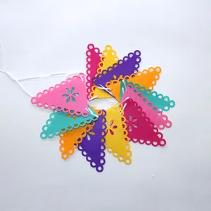 Détail de bannières mexicaines en feutre coloré avec motifs floraux ajourés pour décorations de fête