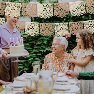 Decorative hollow Mexican Day of the Dead skull banners hanging at a family party scene.