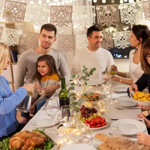 Festive Day of the Dead skull banner hanging over a warm family dinner party table.