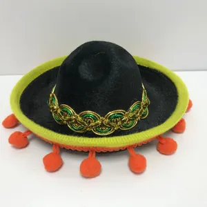 Detailed view of mini Mexican sombrero with gold embroidery and orange pom-poms.