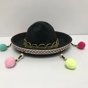 Detailed view of mini black Mexican sombrero hat with colorful pom-poms for parties
