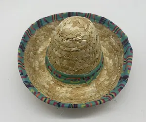 Detailed view of a miniature straw sombrero with a colorful ethnic geometric fabric trim.