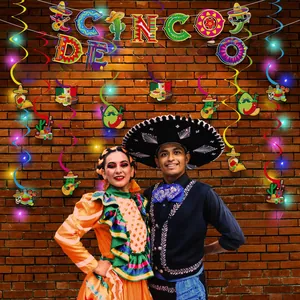 Vibrant Cinco de Mayo party decorations banner and hanging swirls set on brick wall