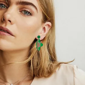 Detailed view of model wearing festive green sombrero earrings for Mexican Fiesta theme