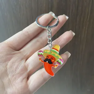 Close-up of a festive Mexican chili pepper acrylic keychain with a yellow sombrero accessory