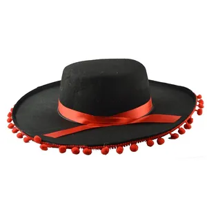 Macro detail of a black Mexican sombrero party hat featuring red ribbon and pom-poms