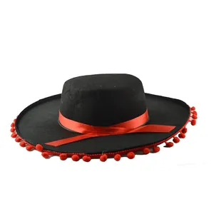 Close-up of black Mexican sombrero with red ribbon and pom-pom trim