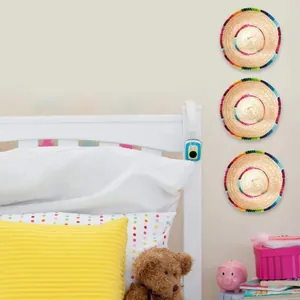 Three mini Mexican straw hats with colorful woven trim displayed as wall decor in a bedroom