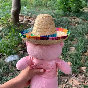 Miniature Mexican straw sombrero with a vibrant colorful striped brim shown on a plush toy.