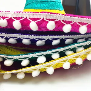 Dettaglio ravvicinato di cappelli di paglia messicani colorati con bordo di pompon bianchi