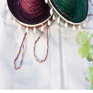 Detailed view of colorful Mexican straw hats with white pompom trim for parties
