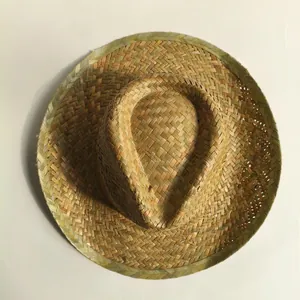 Top view of a natural palm leaf woven Mexican straw hat with a wide brim on a beige background.