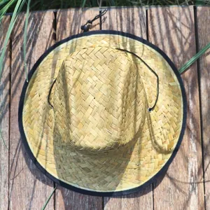 Overhead view of a natural woven sunflower leaf straw hat with adjustable chin strap