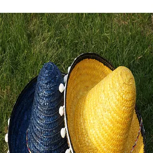 Detailed macro view of vibrant yellow and blue Mexican straw hats with white pom-pom trim
