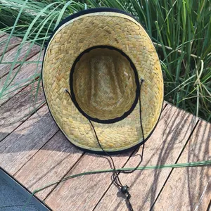 Detailed interior view of a handmade Mexican straw hat with wide brim and chin strap.