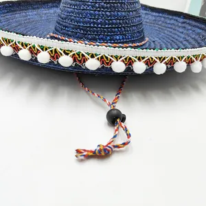 Detalle de sombrero de paja mexicano azul con banda colorida y pompones blancos
