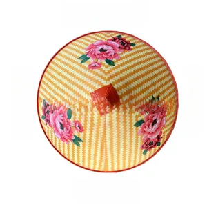 Vista dall'alto di un cappello conico in bambù con motivo floreale di peonie rosa