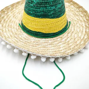 Close-up of a Mexican woven straw hat with green and yellow stripes and pom-poms
