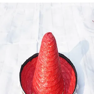 Macro view of a red Mexican straw hat with white pompom trim for Halloween parties