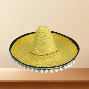 Handcrafted bright yellow Mexican sombrero straw hat with white pom-poms for carnival