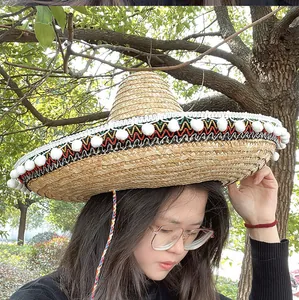 Detailopname van een Mexicaanse sombrero strohoed met kleurrijke biezen en witte pompons
