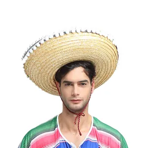 Gros plan d'un sombrero mexicain en paille à large bord avec pompons blancs sur un modèle
