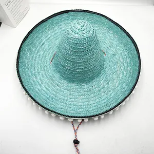 Primer plano cenital de un sombrero mexicano de paja cian con pompones blancos decorativos
