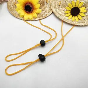 Detail von Mini-Strohhüten für Haustiere mit Sonnenblumen und verstellbaren Kordeln.