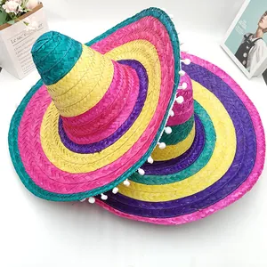 Close-up of colorful hand-woven Mexican straw hats decorated with white pompom trim