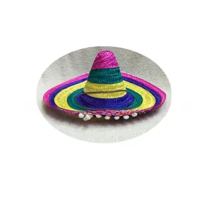 Dettaglio di mini cappello di paglia messicano colorato con frangia di pompon bianchi