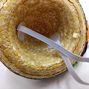 Close-up detail showing the elastic strap and woven texture of a mini Mexican pet straw hat