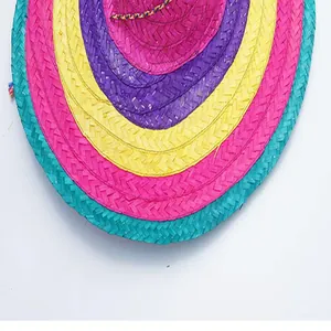 Close-up detail of a colorful Mexican straw hat with vibrant braided pink and yellow rings.