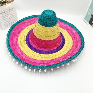 Detailed view of a colorful Mexican straw sombrero with white pom-poms fringe.