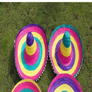 Vibrant multi-colored Mexican straw sombreros with striped patterns placed on green grass