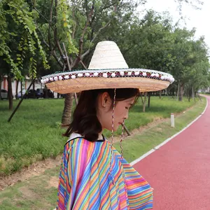 Close-up of Mexican straw sombrero and rainbow striped poncho in outdoor park setting