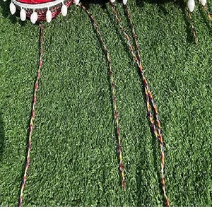Close-up of colorful braided straps and white pom-poms on a Mexican fiesta party hat