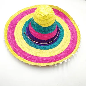 Close-up of a colorful Mexican straw sombrero with white pom-pom trim on the brim