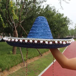 Vibrant blue Mexican straw hat featuring white pom-pom fringe and colorful brim details