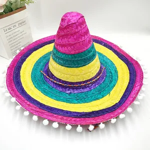 Detailed shot of a colorful Mexican straw hat with white pom-poms and rainbow stripes.