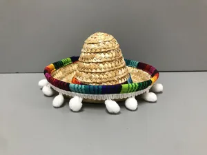 Dettaglio di mini cappello di paglia messicano con bordo colorato e pompon bianchi