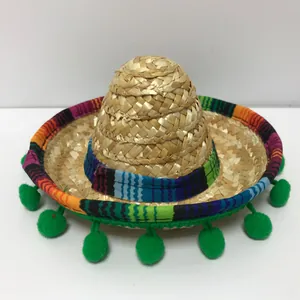Primo piano di un mini cappello di paglia messicano con bordo colorato e pon pon.