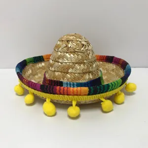 Vista ravvicinata di un mini sombrero di paglia messicano con pon pon gialli vivaci