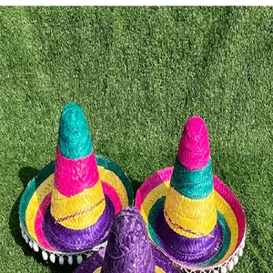 Colorful Mexican straw sombreros with white pom-poms shown on green grass surface