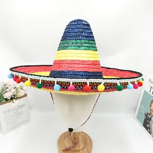 Macro view of colorful Mexican straw sombrero hat featuring festive pom-pom tassels