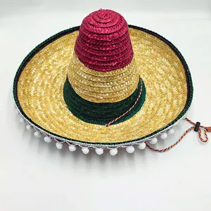 Detailansicht des bunten mexikanischen Strohhuts mit weißen Pompons und dreifarbigem Design.