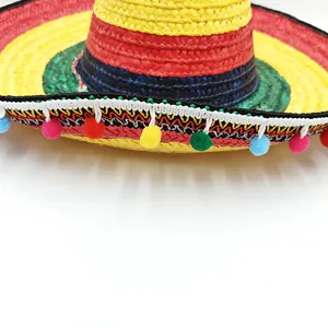 Close-up detail of a colorful Mexican straw hat brim with vibrant decorative pom-poms