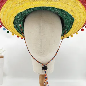 Detail view of a colorful Mexican sombrero straw hat with decorative pompoms on a stand.