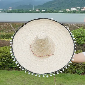 Traditional Mexican straw sombrero with white pom-pom trim for festival parties.