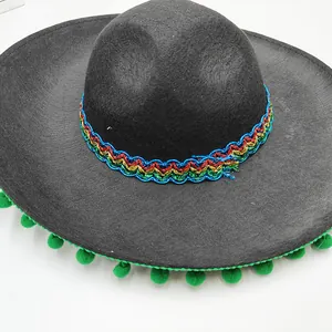 Detail view of black Mexican sombrero with vibrant colorful ribbon and green pom-poms