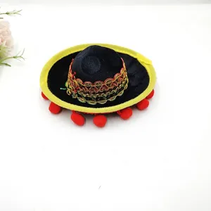 Detailed view of a miniature black Mexican sombrero featuring yellow brim and red pom-poms